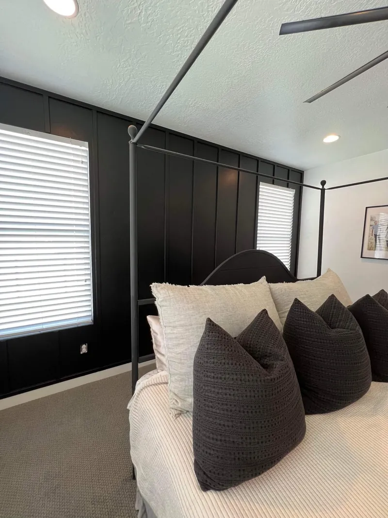 Charcoal board and batten accent wall behind a bed