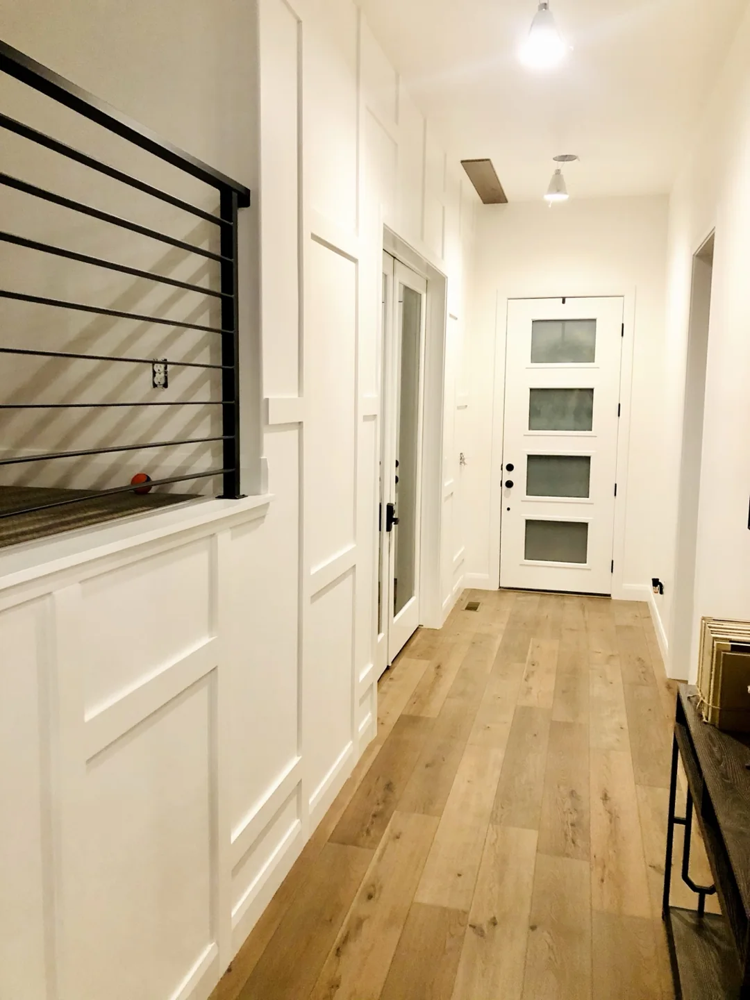 White board and batten paneling along a tall entry hallway