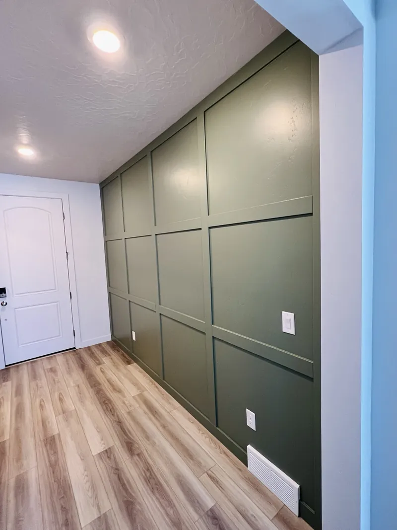 Sage green board and batten wall beside an entry door