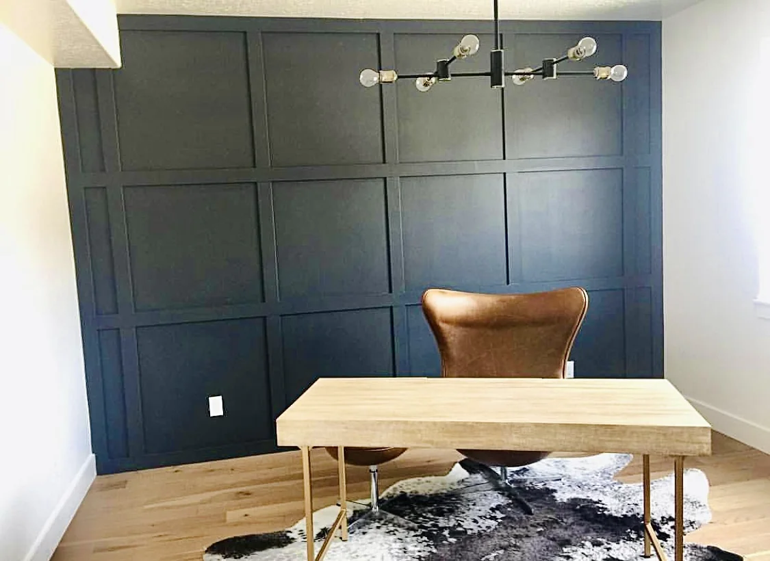 Dark board and batten accent wall behind a desk in a home office