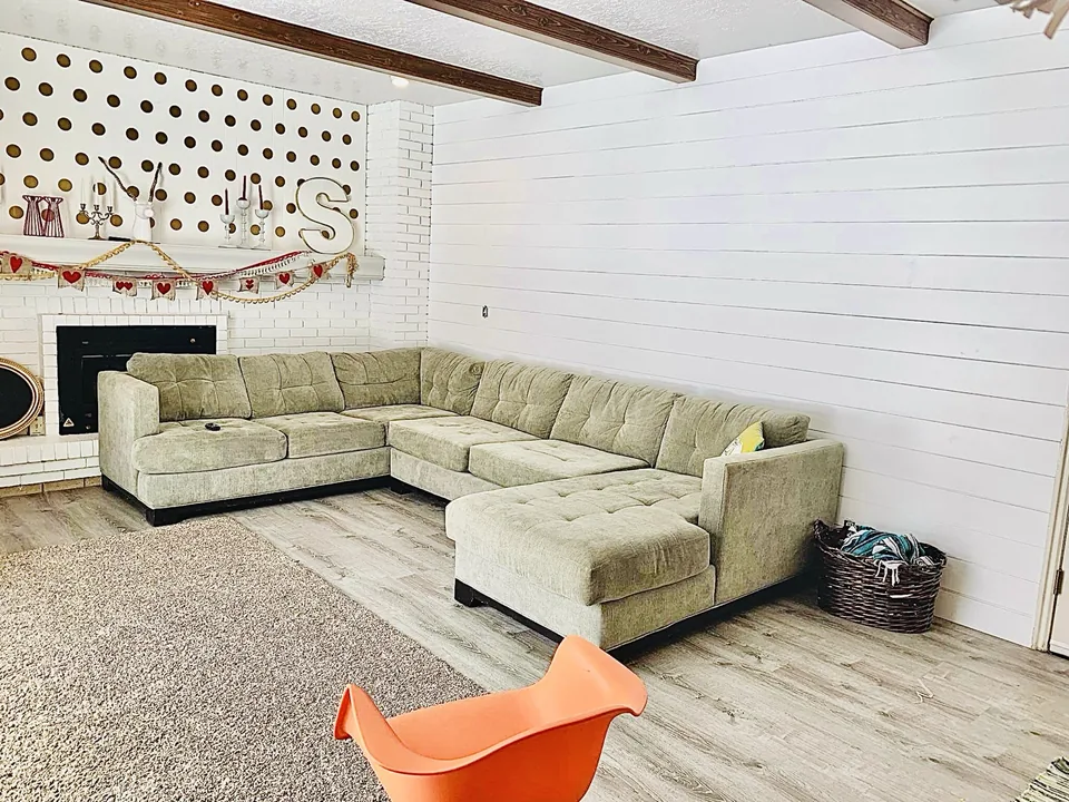 White shiplap accent wall behind a living room sectional